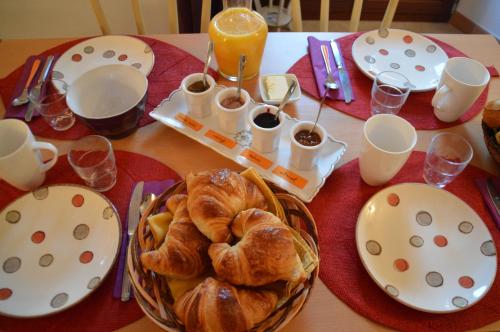 een tafel met borden met eten en croissants erop bij La Bastide Du Claus - Vitaverde in Cruis