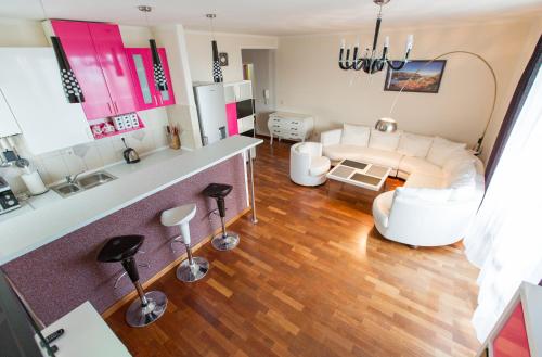 a living room with a white couch and a kitchen at Apartment Green House in Petrovac na Moru