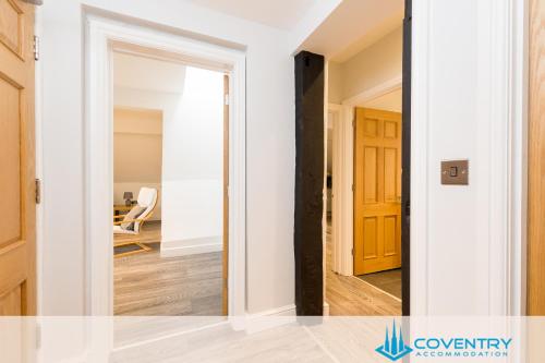 a hallway with a door leading into a living room at 2 Bedroom Apartment, NEC, HS2, BHX, JLR - Devereux House, Hosted By Coventry Accommodation in Coleshill