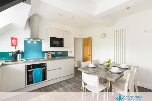 a kitchen and dining room with a table and chairs at 2 Bedroom Apartment, NEC, HS2, BHX, JLR - Devereux House, Hosted By Coventry Accommodation in Coleshill