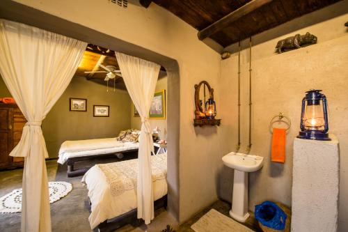a bedroom with a bed and a toilet and a sink at Rio Dos Elefantes River Camp in Hoedspruit