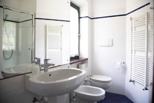 uma casa de banho branca com um lavatório e um WC em Appartamento Napoleone by HelloElba em Portoferraio