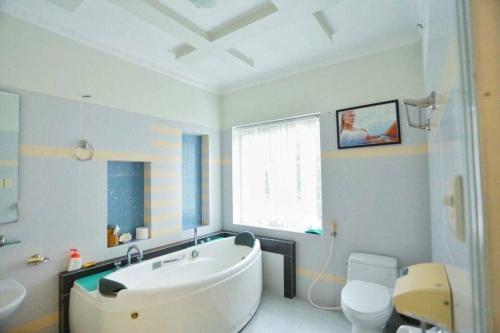 a bathroom with a white tub and a toilet at Sea Villa - 22 Bà Triệu in Vung Tau