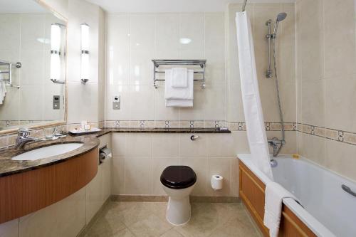 a bathroom with a sink and a toilet and a tub at The Bull in Gerrards Cross