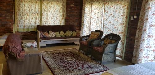 a living room with two chairs and a couch at Rio Dos Elefantes River Camp in Hoedspruit