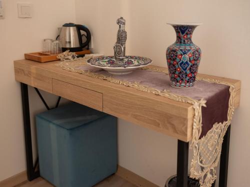 una mesa de madera con un jarrón encima en THE LAİLA HOTEL, en Estambul