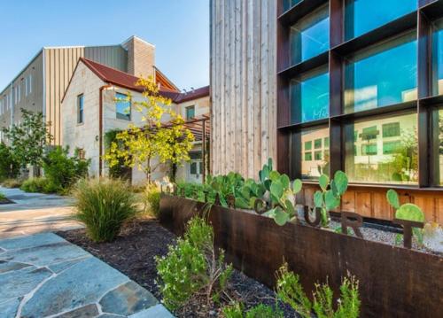 a garden in front of a building at Lone Star Court, by Valencia Hotel Collection in Austin