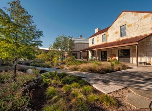 an exterior view of a house with a pathway at Lone Star Court, by Valencia Hotel Collection in Austin