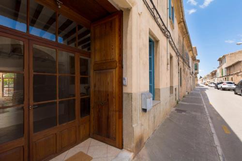 a building with a wooden door on a street at Ca sa Padrina in Llucmajor