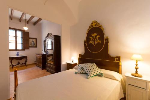 a bedroom with a large bed and a desk at Ca sa Padrina in Llucmajor