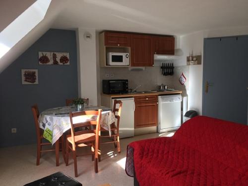 une cuisine avec une table et des chaises ainsi qu'une cuisine avec une table et un canapé dans l'établissement Résidence l'Eterle, à Luz-Saint-Sauveur