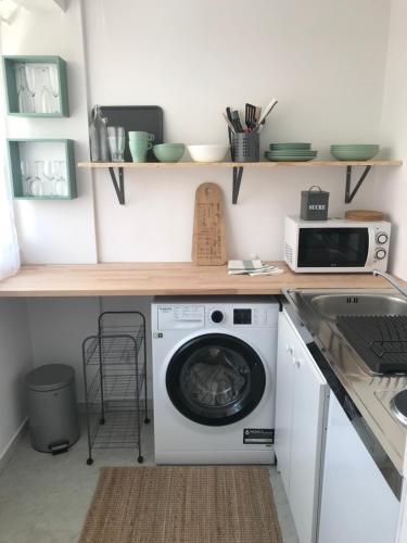 une cuisine avec un lave-linge et un micro-ondes dans l'établissement GREEN STUDIO CANNES CENTRE, à Cannes