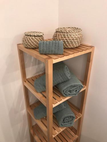 - un porte-serviettes en bois avec des serviettes et des paniers dans l'établissement GREEN STUDIO CANNES CENTRE, à Cannes