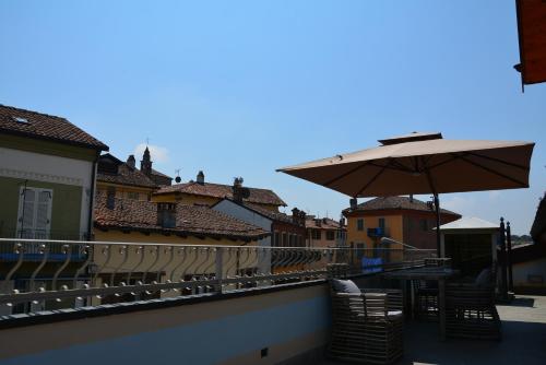 a balcony with a table and an umbrella at Altezza in La Morra