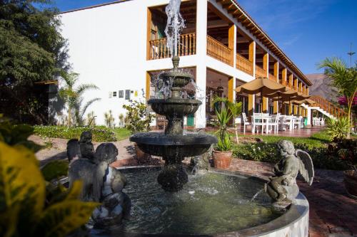 a fountain in front of a house with a building at Casa Hacienda Nasca Oasis in Nazca