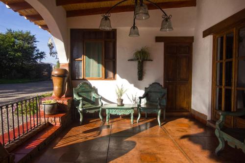 a porch with chairs and a table on a house at Casa Hacienda Nasca Oasis in Nazca