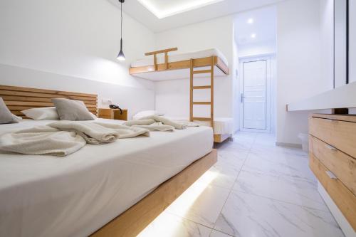 a white bedroom with two beds and a ladder at Lardos Bay Hotel in Lardos