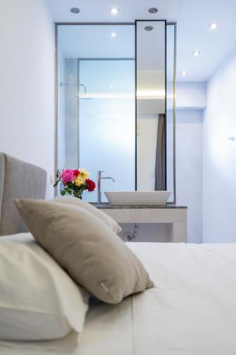 a pillow on a bed with a sink in a bathroom at Lardos Bay Hotel in Lardos