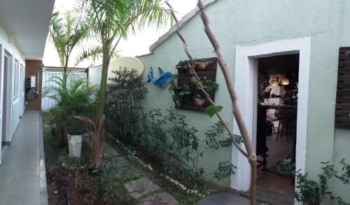 a house with a palm tree on the side of it at Airport Pousada in Cabo Frio