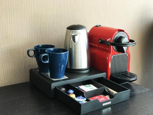 a tray with a coffee maker and a suitcase at Mike's Four in Düsseldorf