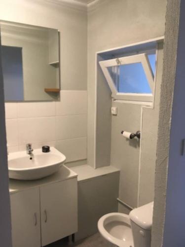 une salle de bain blanche avec un lavabo et des toilettes dans l'établissement au chevet des canaux de verdun, à Verdun-sur-Meuse