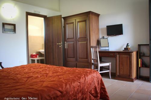 a bedroom with a bed and a desk and a television at Agriturismo San Matteo in Tarquinia