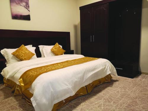 a bedroom with a large bed with yellow pillows at Bzul Furnished Units in Riyadh