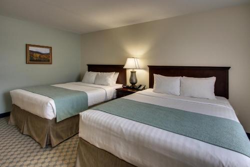 a hotel room with two beds and a lamp at The Inn at Wise in Wise