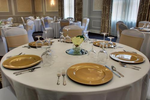 a white table with gold plates and silverware at The Inn at Wise in Wise