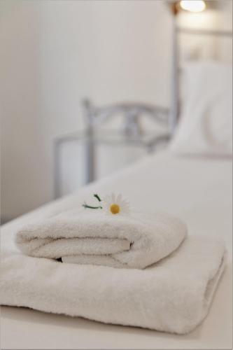 a white towel with a flower on top of it at Aggelos Apartments & Deluxe Studios in Nydri