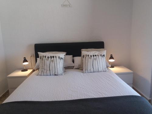 una camera da letto con un letto con due lampade sopra di Casa Belle a Jávea