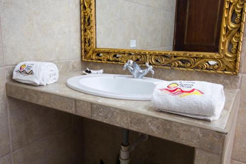 a bathroom sink with two towels and a mirror at Casa Hacienda Nasca Oasis in Nazca