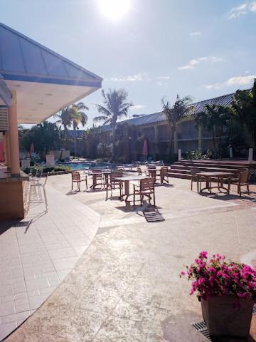an outdoor patio with tables and chairs and flowers at Royal Islander Hotel in Freeport