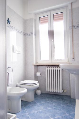 a white bathroom with a toilet and a sink at Appartamento IRIS in Garda