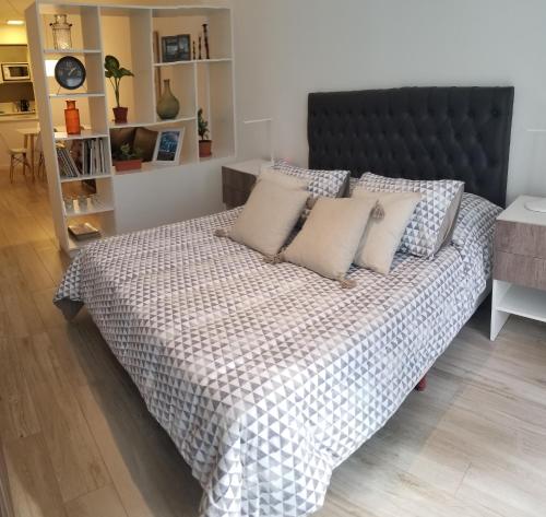 a bed with pillows on it in a room at Fabuloso departamento con todo y cerca de todo in Buenos Aires