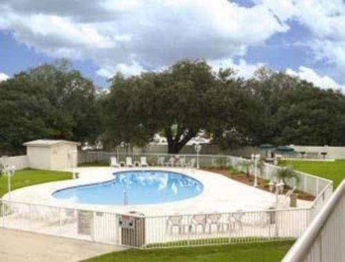 a large swimming pool in a yard with a fence at Motel 6-Jacksonville, NC in Jacksonville