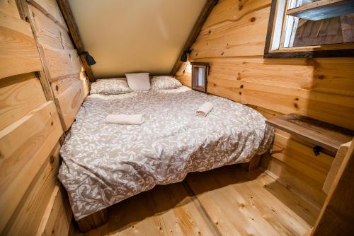 a bedroom with a bed in a wooden cabin at Apartment with Sauna pr' Geči in Dobova