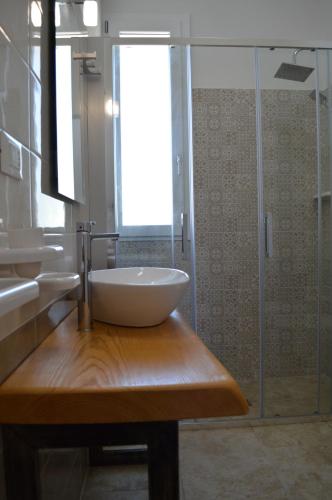 a bathroom with a sink and a glass shower at Residenza Case Arse in Torre Lapillo
