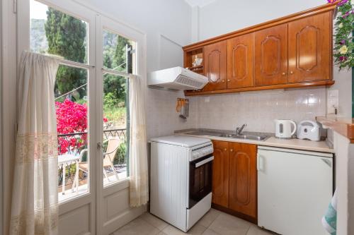 a small kitchen with a sink and a window at Rapanos Apartments in Paleokastritsa