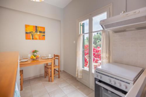 a kitchen with a stove and a table and a window at Rapanos Apartments in Paleokastritsa
