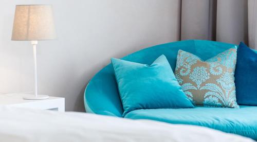 a blue chair with pillows in a bedroom at Villa Christina in Pörtschach am Wörthersee