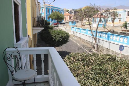 a balcony of a house with a chair and a street at Casa Colonial Koenig in São Filipe