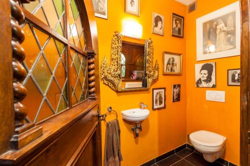 ein orangefarbenes Badezimmer mit einem Waschbecken und einem WC in der Unterkunft Guesthouse Maison de la Rose in Brügge