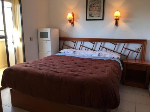 sypialnia z łóżkiem, lodówką i dwoma lampami w obiekcie APARTAMENTO CERCA DE LA PLAYA w mieście Aguadulce
