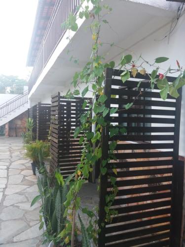 a row of black wooden benches with plants at Pouso do Rio in Pirenópolis