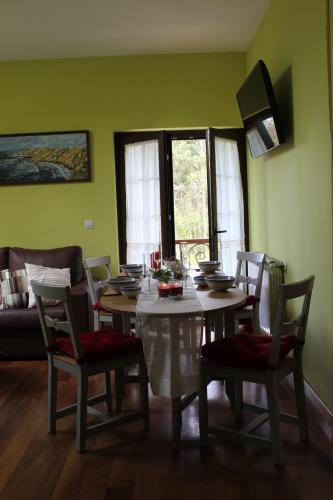a dining table and chairs in a room with green walls at Apartamentos rurales la Aguilera in Oviñana