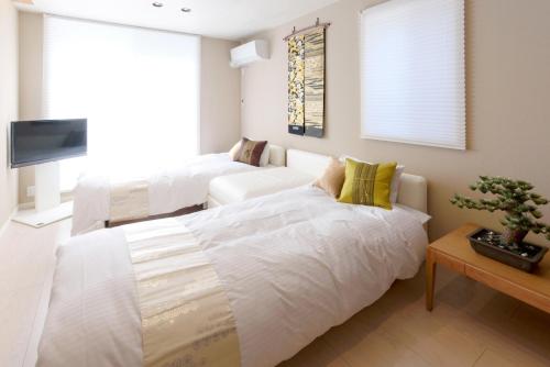 Een bed of bedden in een kamer bij Libre Hosai Stay Kanazawa - Vacation STAY 3359