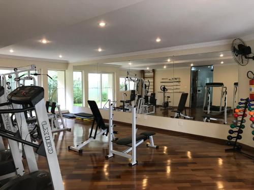 una habitación con un gimnasio con máquinas de correr y un espejo en Chateau du Loire Apartamento, en Campos do Jordão