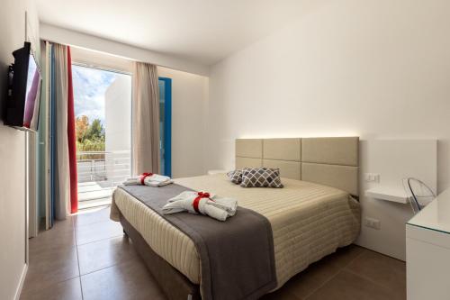a bedroom with a bed and a large window at Affittacamere Sirius in San Vito lo Capo
