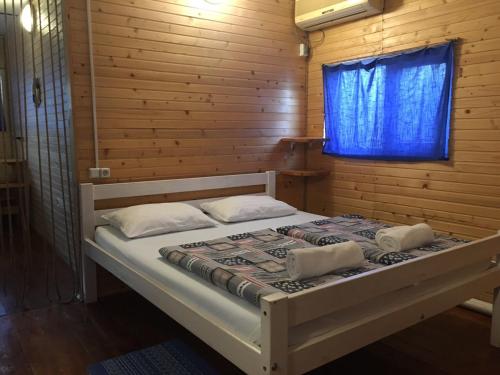 チョロノモスクにあるChernomorsky Mayakの青い窓が備わる木造の部屋のベッド1台分です。
